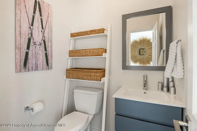 a bathroom with a toilet sink and mirror