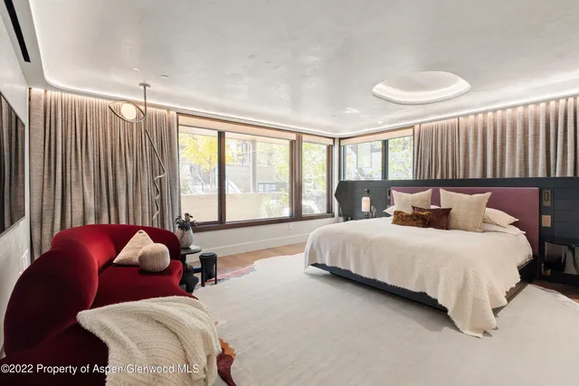 a bedroom with bed and a large window