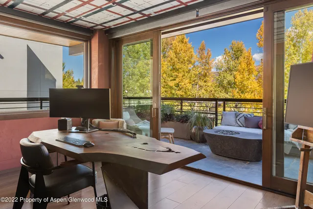 a view of a workspace with a table and chair