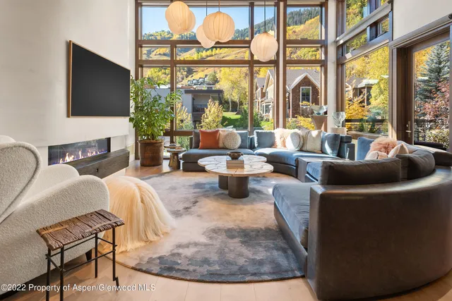 a living room with fireplace furniture and a large window