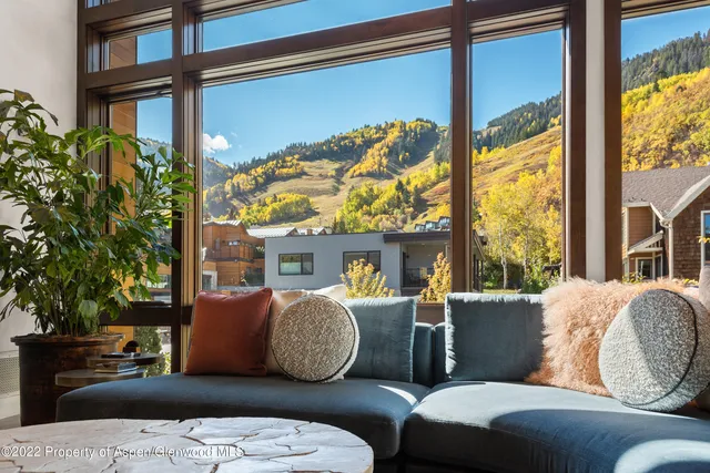 a living room with couches a flat screen tv and balcony
