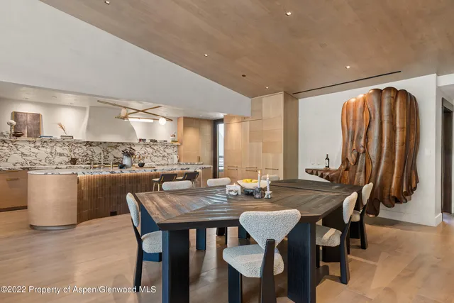 a dining hall with stainless steel appliances a table and chairs