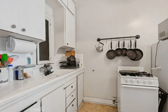 a kitchen with a stove and a white cabinets