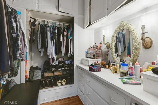 a view of walk in closet with clothes and shoes