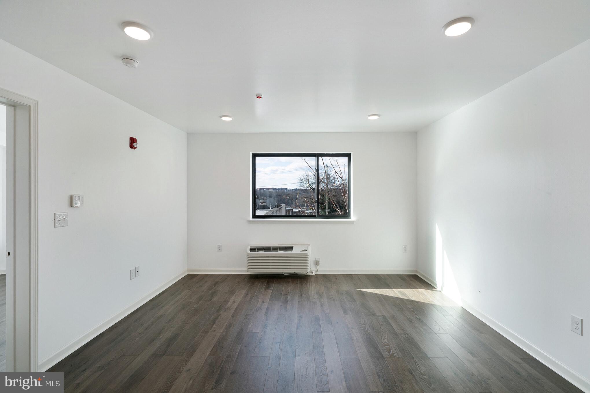 5420 Ridge Avenue, Unit 406 Philadelphia, PA 19128 - Photo 4 of 10 an empty room with wooden floor and windows