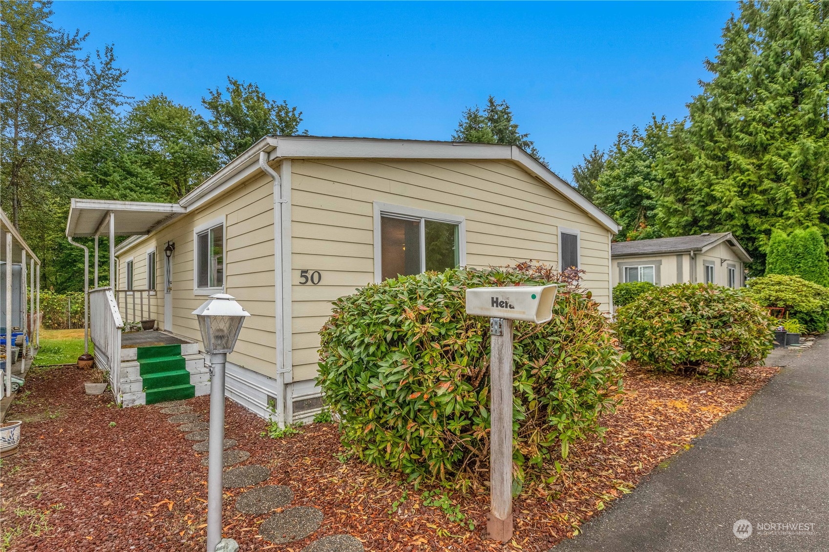 212 Old Owen Road, Unit 50 Sultan, WA 98294 - Photo 1 of 25 a view of a house with backyard and sitting area