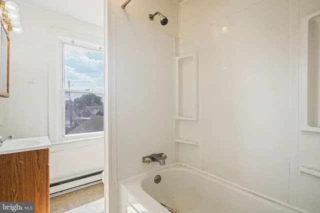 a bathroom with a tub shower and sink