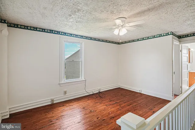 a view of a room with wooden floor chandelier and windows