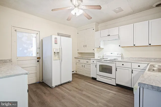 a kitchen with white cabinets and white appliances
