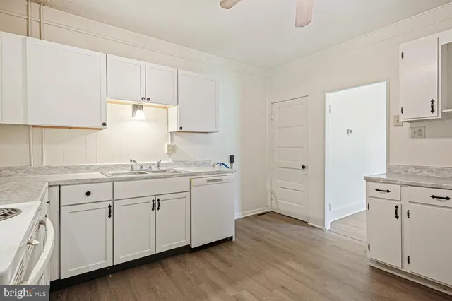 a kitchen with granite countertop white cabinets and white appliances