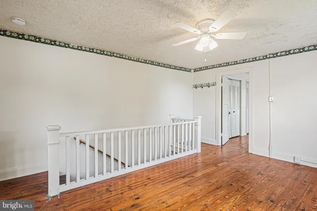 a view of a room with wooden floor fan and windows
