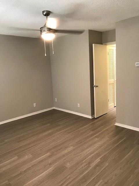 18240 Midway Road, Unit 303 Dallas, TX 75287 - Photo 15 of 22 Unfurnished room featuring ceiling fan, dark wood-style floors, and a textured ceiling