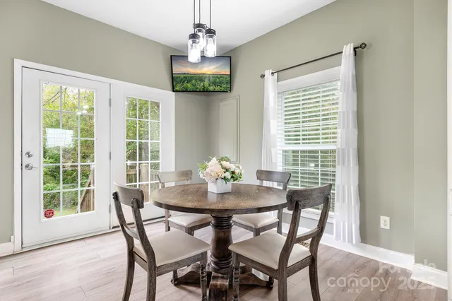 a dining room with furniture window and wooden floor