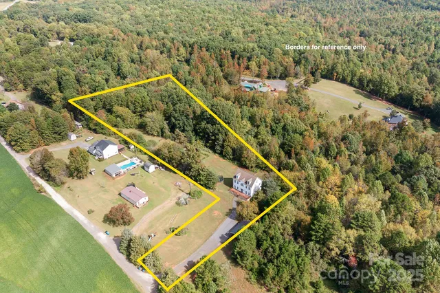an aerial view of a house with a yard and lake view