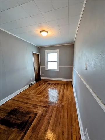 a view of empty room with wooden floor