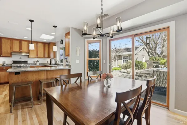 a view of a dining room and livingroom with furniture wooden floor a chandelier