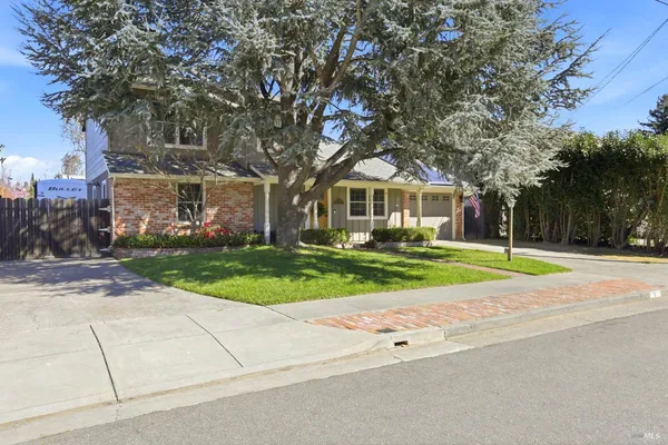 a view of house with outdoor space and trees in the background