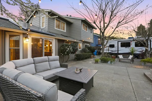 a view of a patio with couches and table and chairs and potted plants