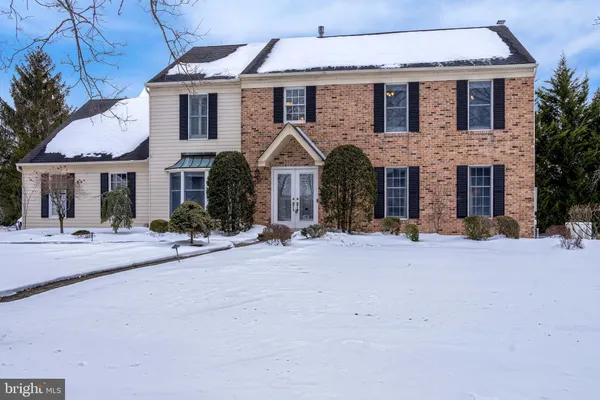 a front view of a house with yard and a tree