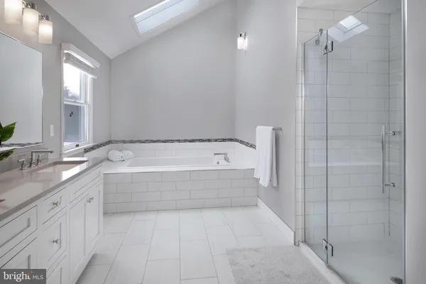 a spacious bathroom with a tub sink and shower