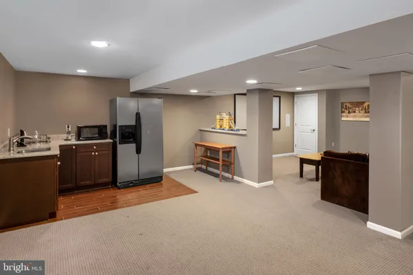 a view of a kitchen with refrigerator and chairs