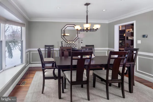 a view of a dining room with furniture a chandelier and wooden floor