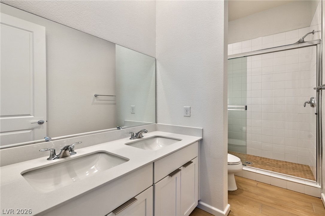3327 Esker Rdg Avenue Henderson, NV 89044 - Photo 13 of 24 A well-appointed bathroom offers a double vanity and a glass-enclosed shower.