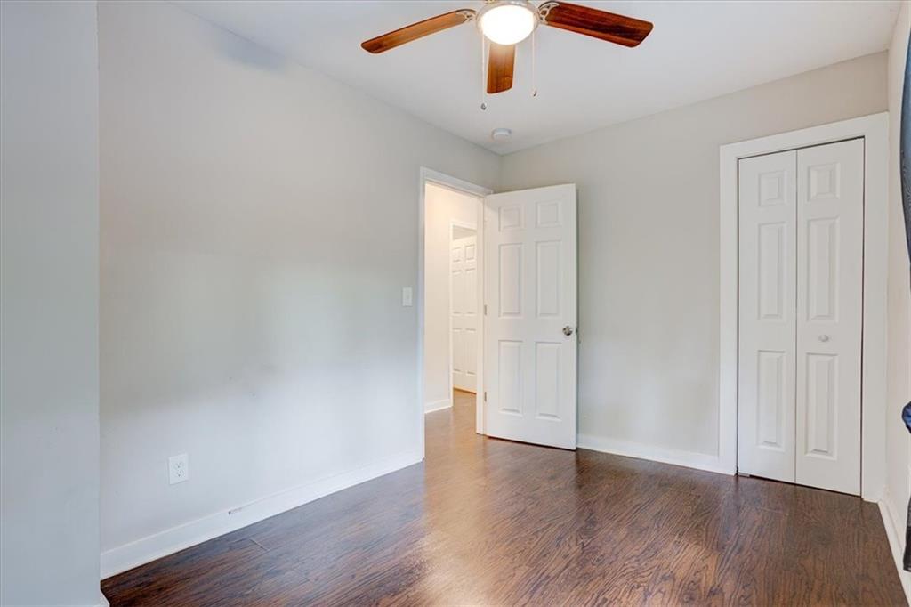 174 Rivertown Road Fairburn, GA 30213 - Photo 19 of 33 an empty room with wooden floor chandelier fan and closet area