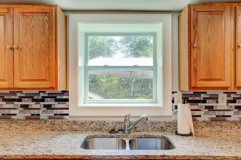 a kitchen with granite countertop a sink and a window