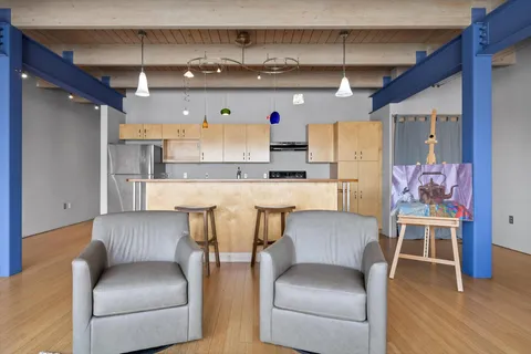 a kitchen with stainless steel appliances kitchen island granite countertop a table and chairs in it