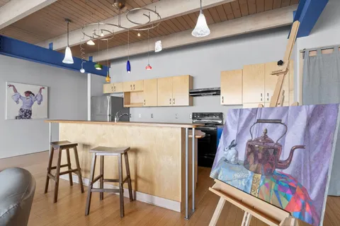 a kitchen with stainless steel appliances kitchen island granite countertop furniture and a refrigerator
