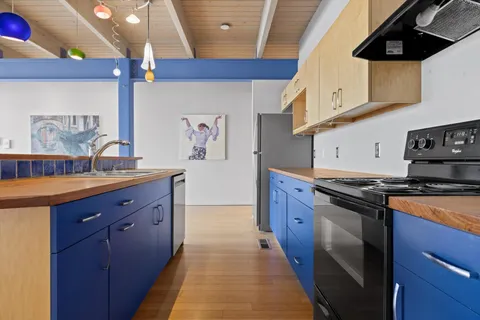 a kitchen with stainless steel appliances granite countertop a stove a sink and a refrigerator