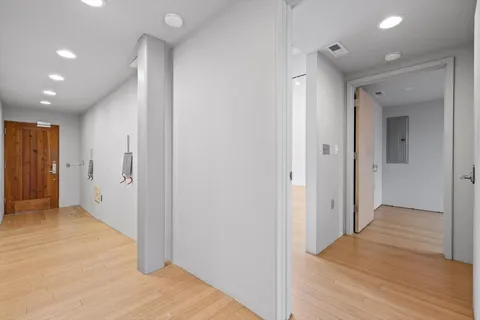 a view of hallway with a large window and wooden floor