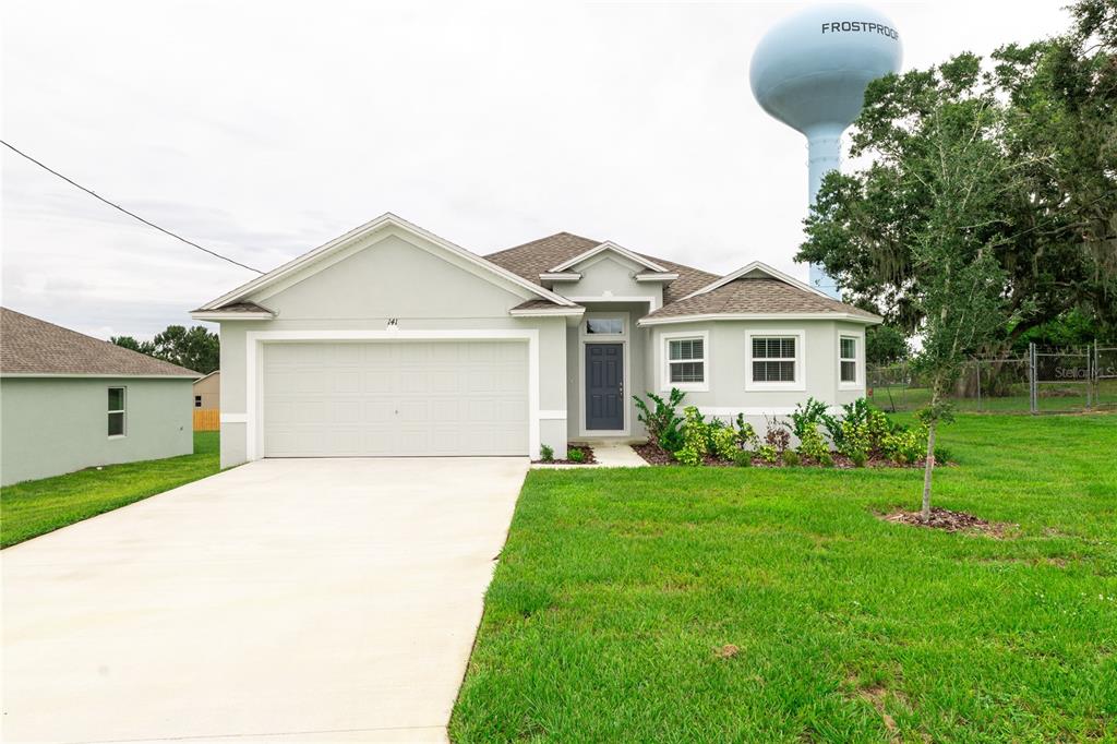 141 West 6th Street Frostproof, FL 33843 - Photo 1 of 1 a front view of a house with a garden and yard