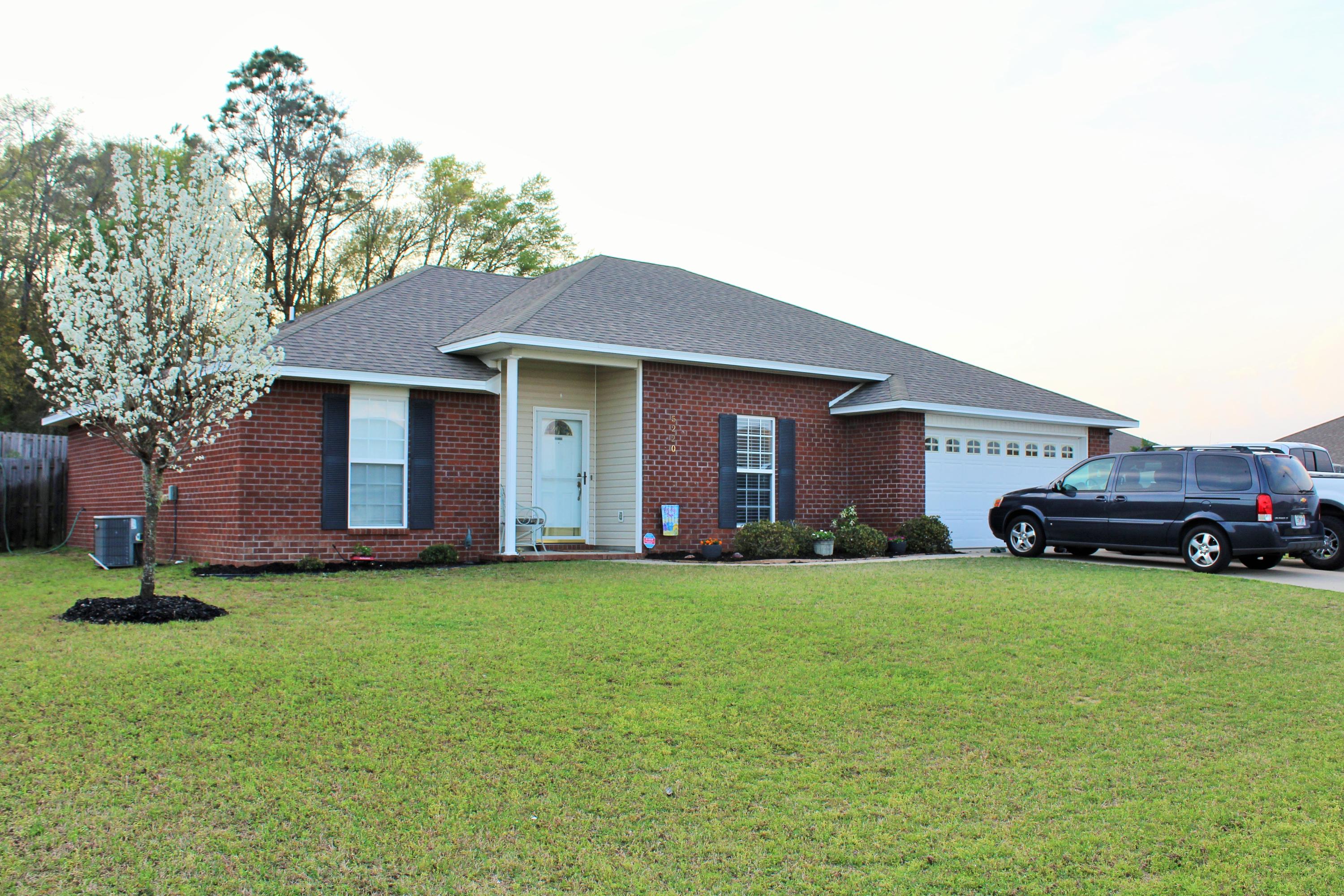 5220 Moore Loop Crestview, FL 32536 - Photo 1 of 24 a view of a house with a yard and garage
