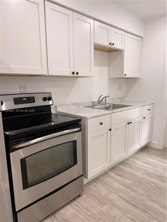 a kitchen with granite countertop white cabinets and appliances