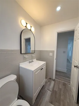 a bathroom with a toilet sink and mirror