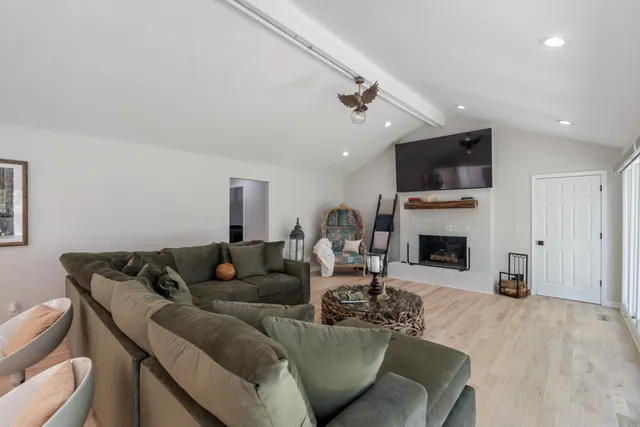 a living room with furniture a fireplace and a flat screen tv