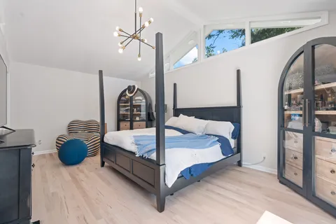 a bedroom with bed and a flat tv screen on dresser