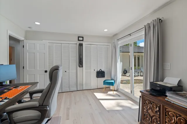 a spacious bedroom with a bed and wooden floor