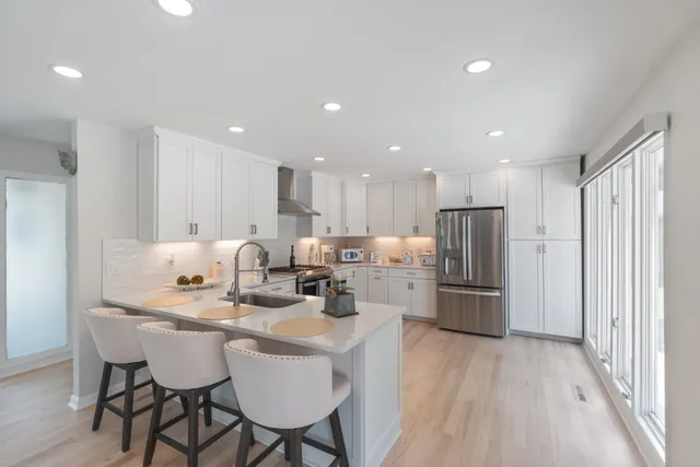 a kitchen that has a lot of cabinets in it and wooden floors