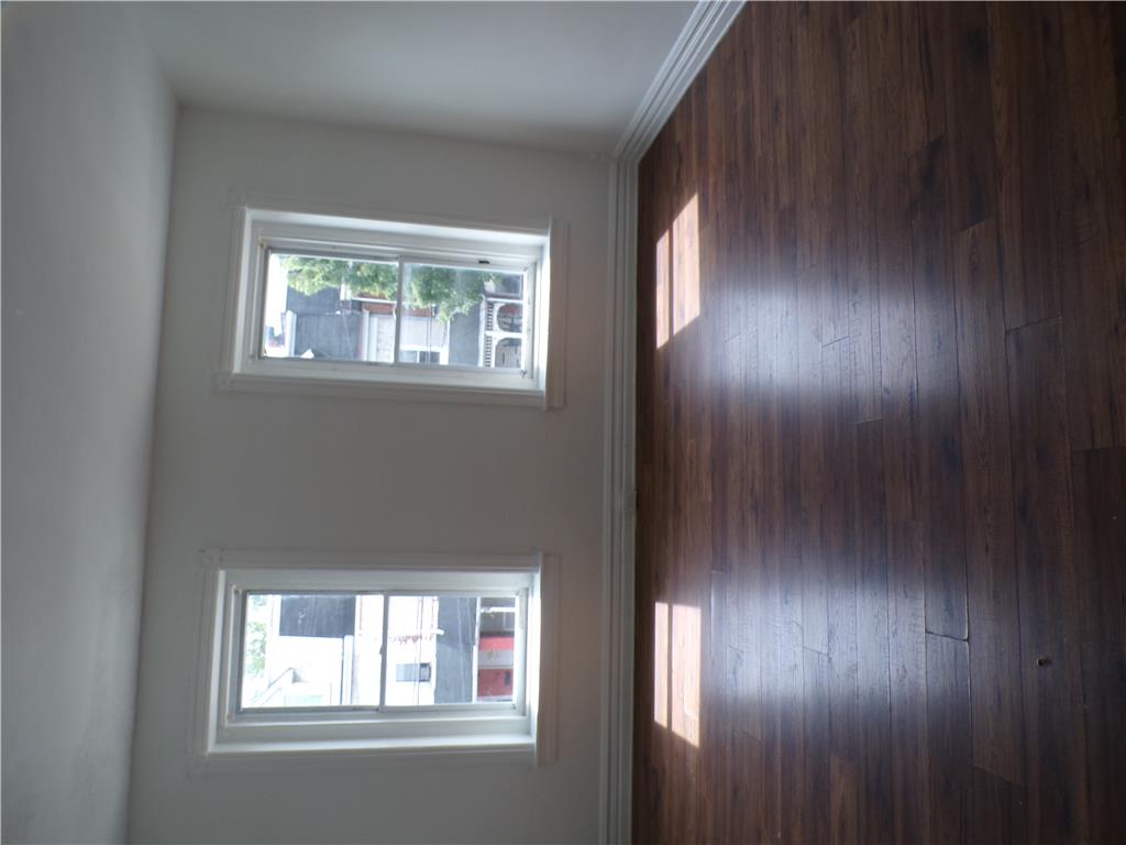 111 Ridge Avenue Allentown, PA 18102 - Photo 12 of 15 Second floor private bedroom #2 well-lit interior space showcasing rich hardwood flooring and clean, minimalist walls.