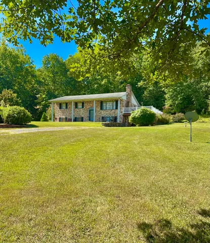 a view of a house with yard and sitting area