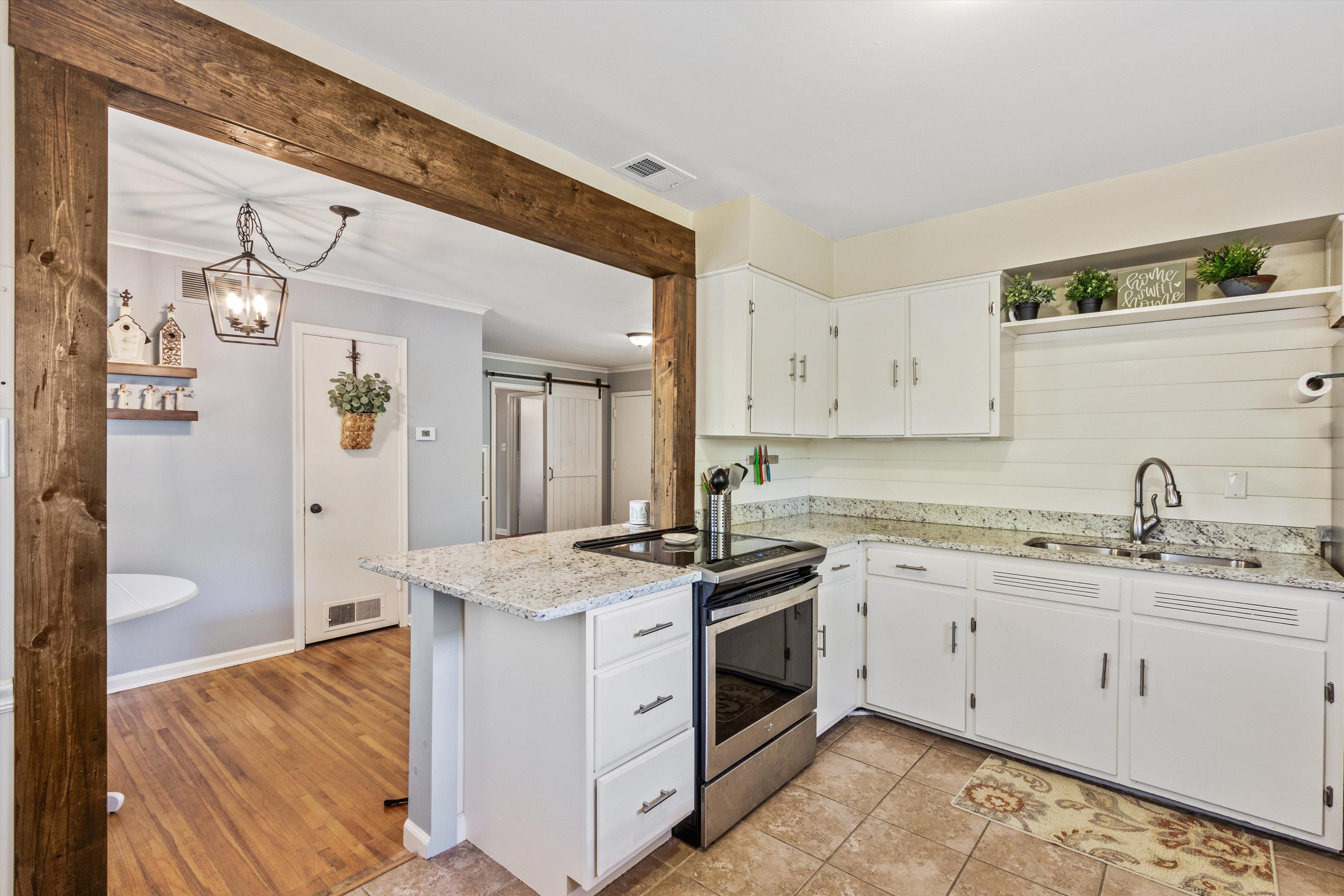 4951 Flamingo Road Memphis, TN 38117 - Photo 8 of 27 Kitchen featuring white cabinetry, light-toned countertops, and an integrated stainless steel range