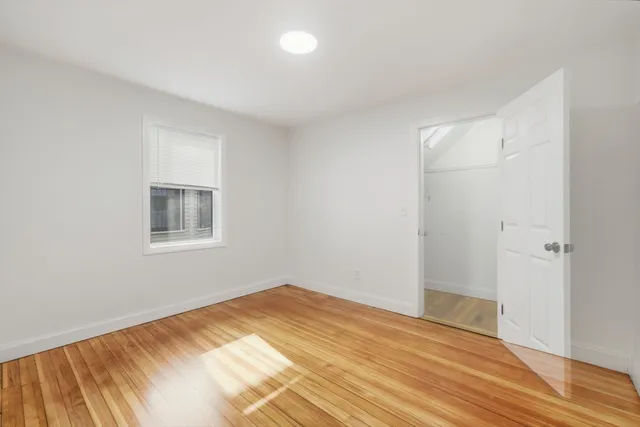 a view of a room with wooden floor and a bathroom