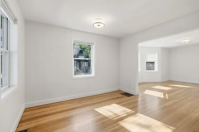 a view of a room with wooden floor and window