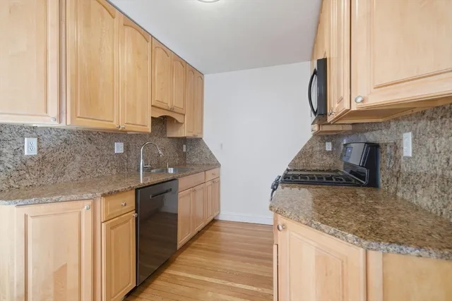 a kitchen with stainless steel appliances granite countertop a sink stove and cabinets