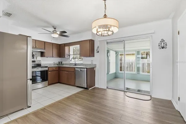 a open kitchen with a refrigerator a sink cabinets and wooden floor