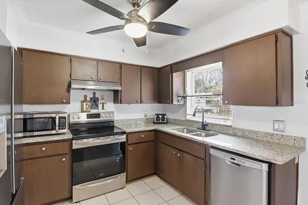 a kitchen with a sink dishwasher a stove and a refrigerator with wooden floor