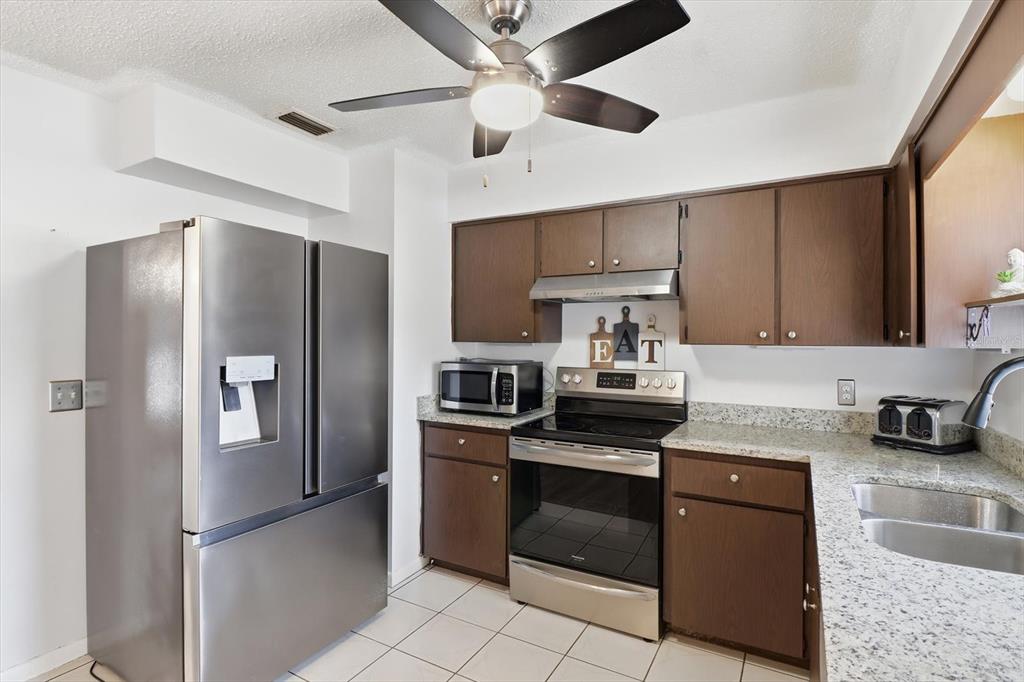 2341 South Whitier Point Homosassa, FL 34448 - Photo 15 of 36 a kitchen with stainless steel appliances granite countertop a refrigerator sink and stove
